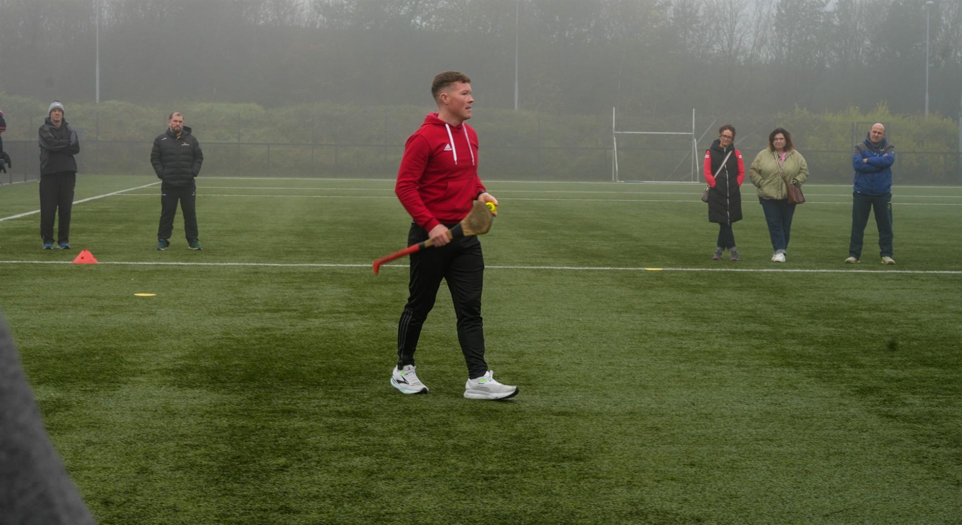 Shane Hassett coaching a group of coaches on an all weather pitch